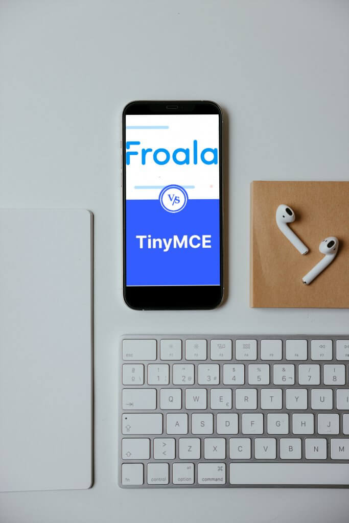 A smartphone on a desk displaying Froala vs. TinyMCE comparison on its screen.